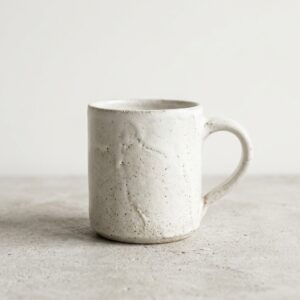 Mug Coquille, en blancs cassés, collection Craie, vue de face sur fond uni.