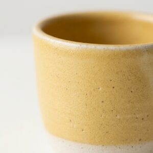 Gros plan sur la texture de l'émail jaune de Tasse Miel Pâle.